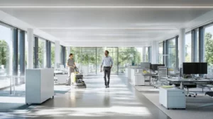 Studie zu Reinigungsfirma buchen für Startups und Unternehmen: Eine Frau bedient eine Bodenwischmaschine im verglasten Großraumbüro, während ein Geschäftsführer die professionelle Büroreinigung beobachtet.